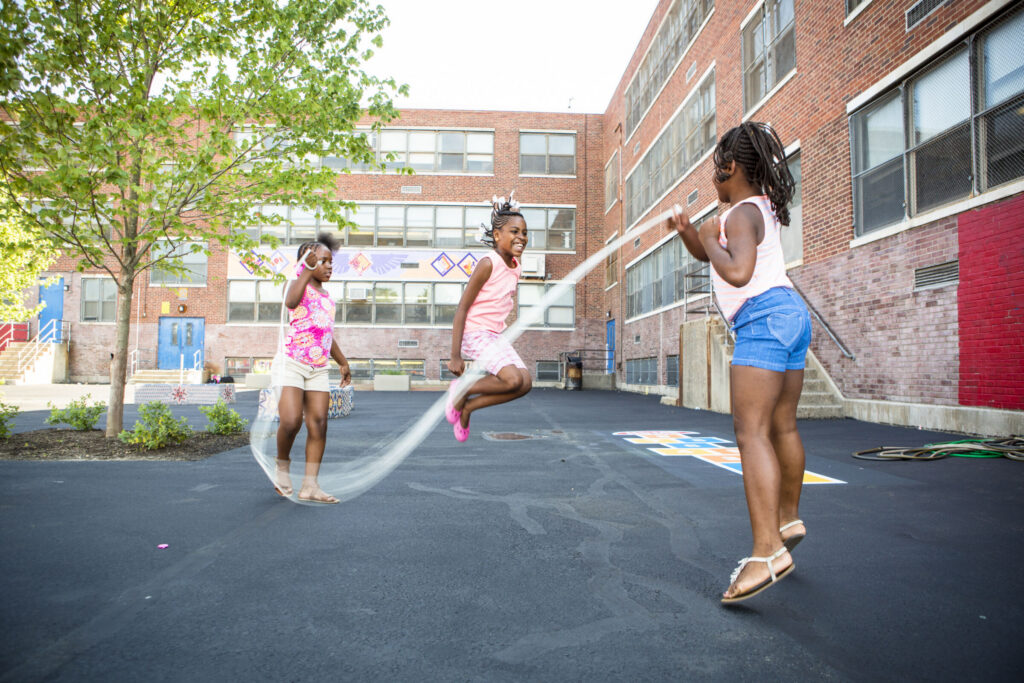 Children enjoying an outdoor recreation space at a city school playground.